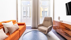 Ein stilvolles Wohnzimmer mit einer Couch, einem Sessel und einer Holzkommode.