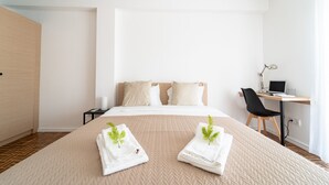 Una habitación de hotel con una cama, un escritorio y una silla.