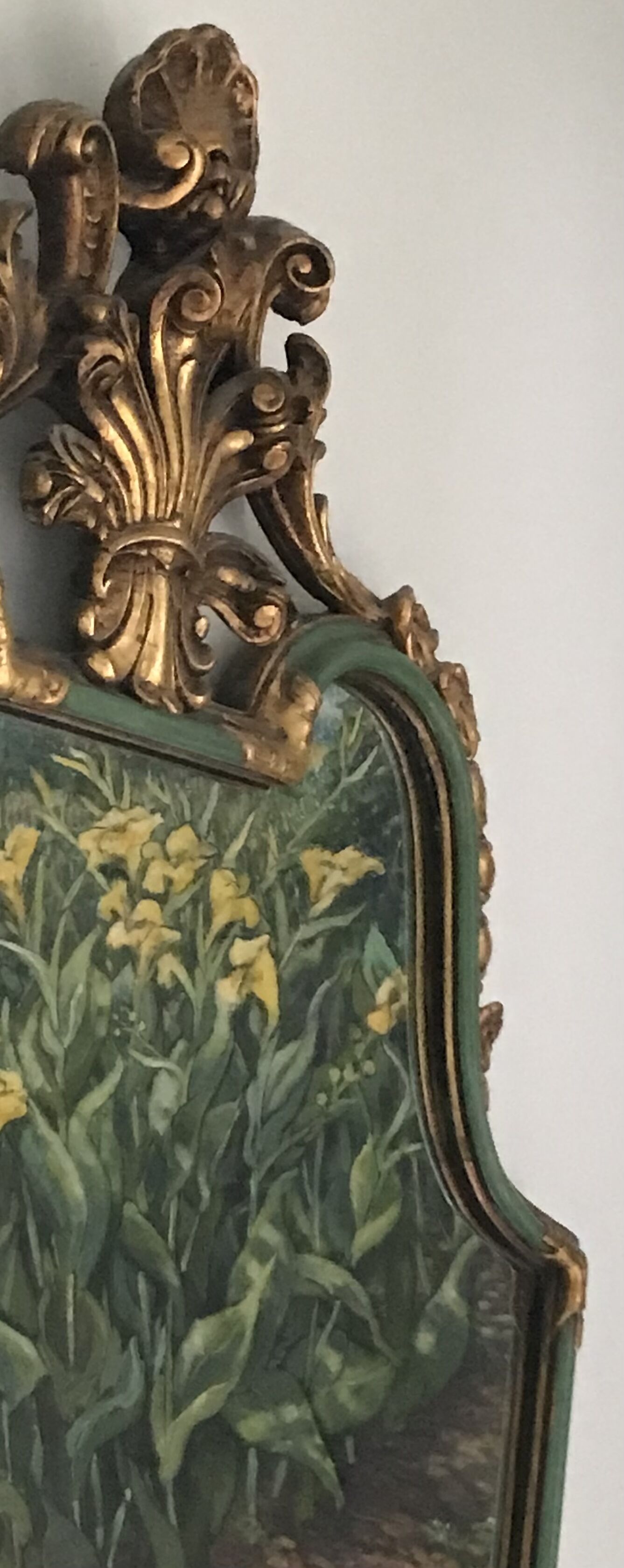 Een sierlijk lijstwerk met een gedetailleerd gouden ontwerp en een schilderij van gele bloemen.