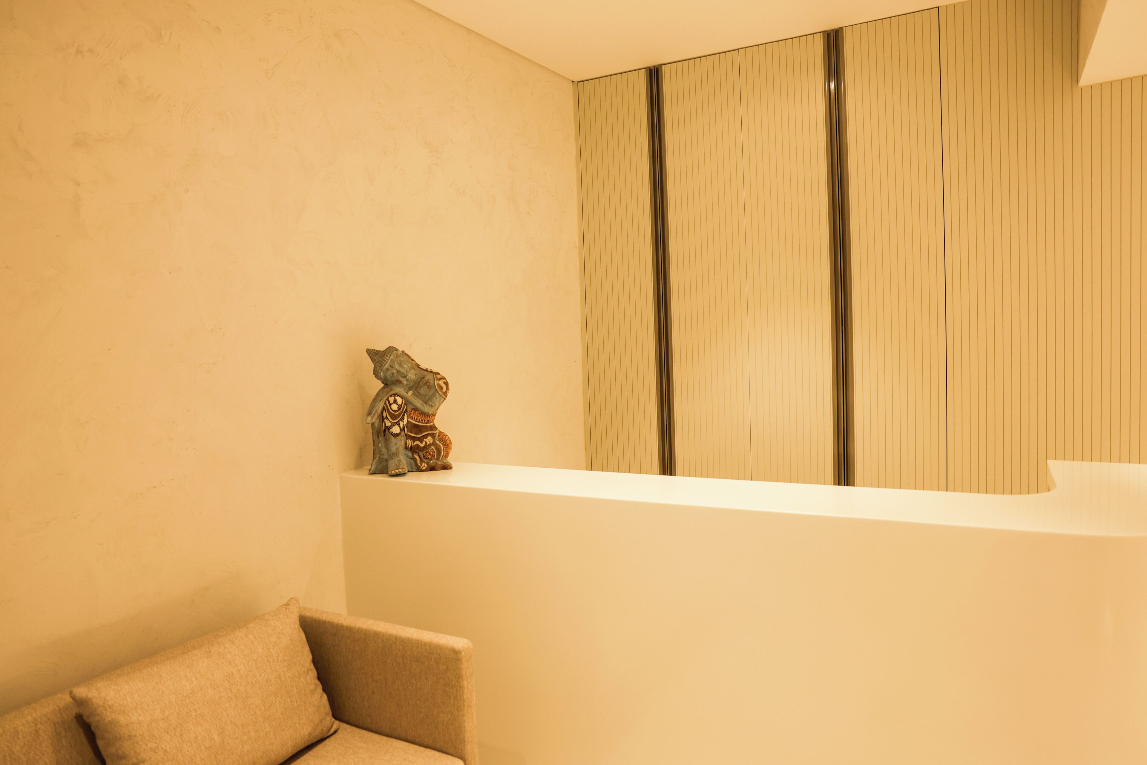 A modern interior with a reception desk, a decorative sculpture, and a minimalist design.