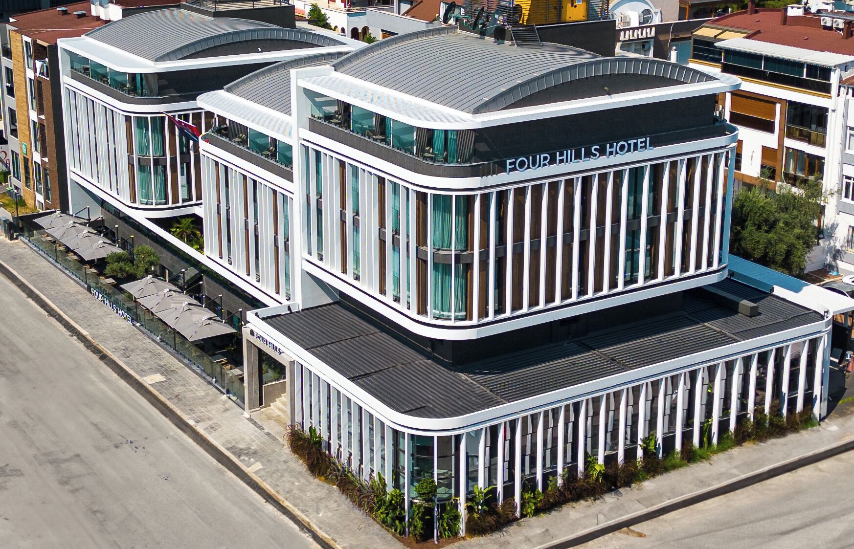 A modern hotel with a curved facade, large windows, and a flat roof.