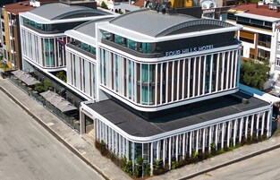 A modern hotel with a curved facade, large windows, and a flat roof.