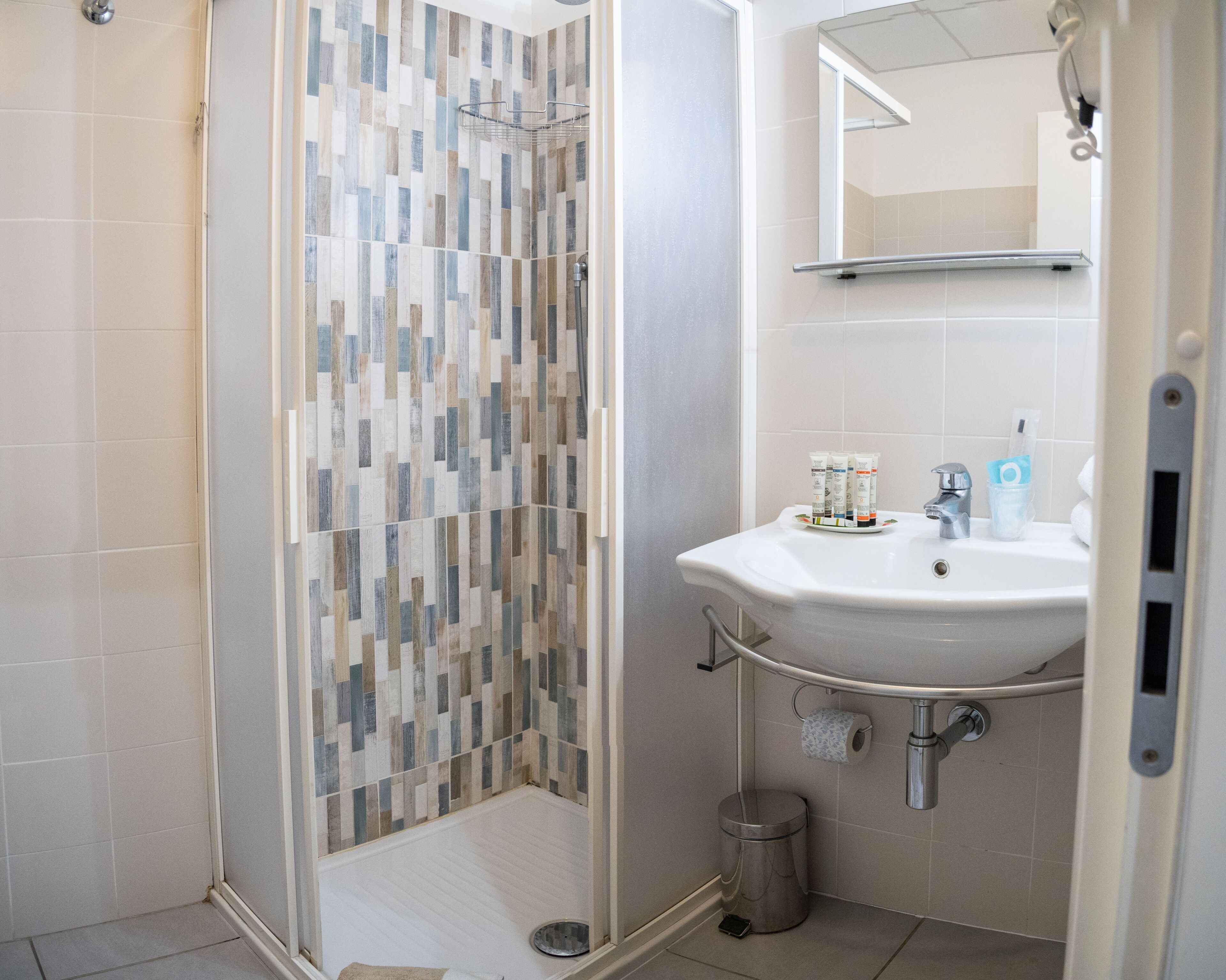 A bathroom with a shower, sink, and toilet.