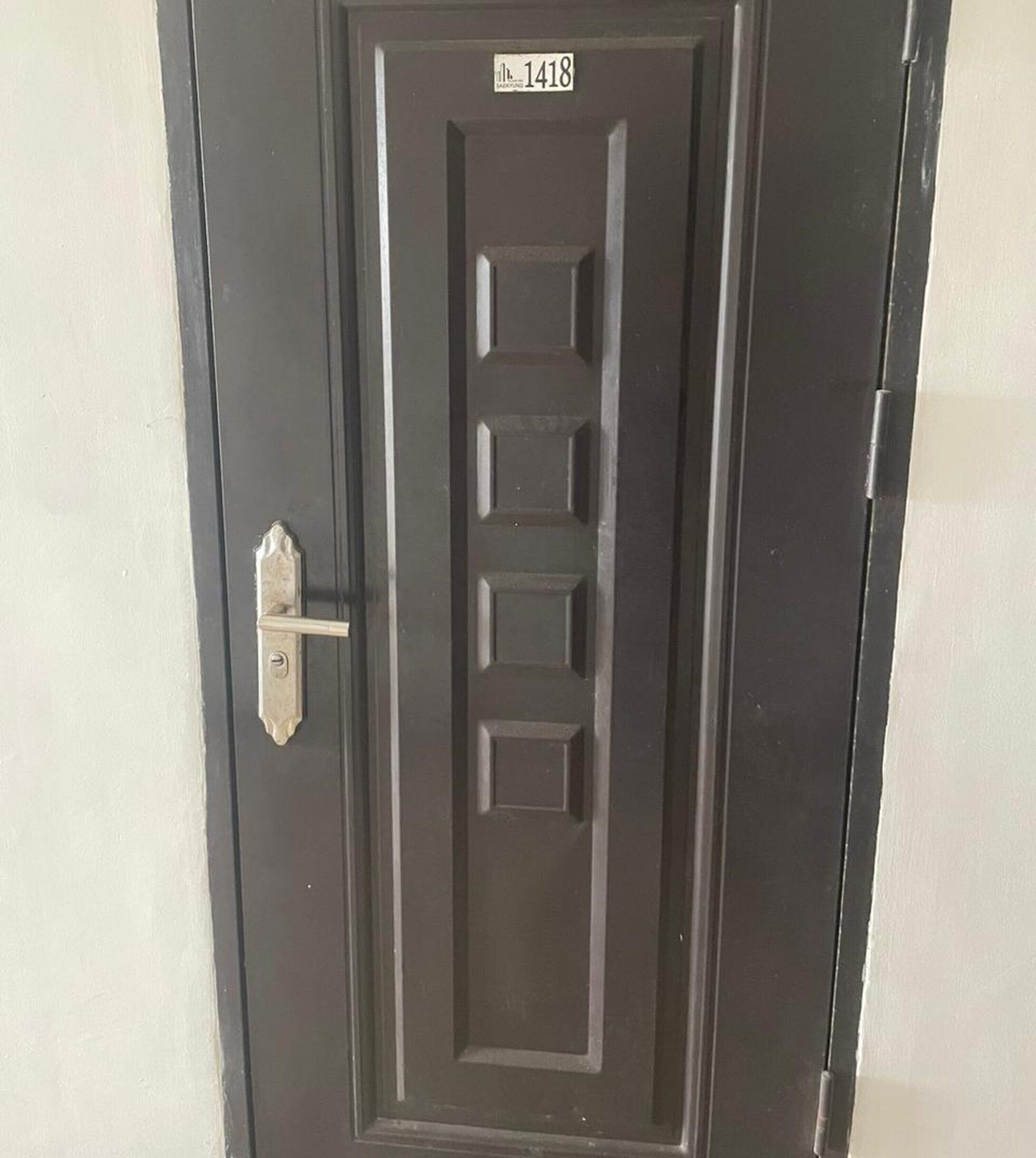 A black door with a number plate reading "1418" and a simple metal handle.