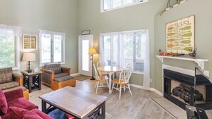 Un salon chaleureux avec une cheminée, une table à manger et des sièges confortables.