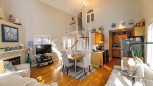 A spacious living room with a fireplace, a dining area, and a kitchen.