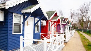 A row of colorful beach houses with white railings and a pathway. - Ağva Tias Shelale Otel (Sile)