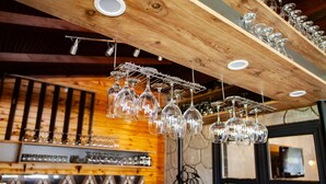 A bar area with hanging wine glasses and a rack of bottles. - Ağva Tias Shelale Otel (Sile)