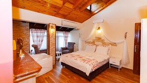 A bedroom with a wooden ceiling, a bed with white bedding, a small bedside table, a chair, and a window with curtains. - Ağva Tias Shelale Otel (Sile)