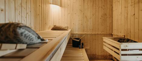 Un sauna de madera con bancos y un balde.