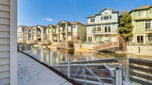 Un hilera de casas adosadas junto a un canal con un puente peatonal.
