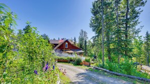 Metsän keskellä sijaitseva maalaishenkinen mökki, jonka luo johtaa mutainen polku.