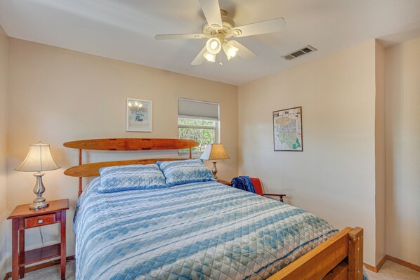 A bedroom with a bed, ceiling fan, window, and wall art. - Hawkins Vacation Rental w/ On-site Lake Access! (Hawkins)