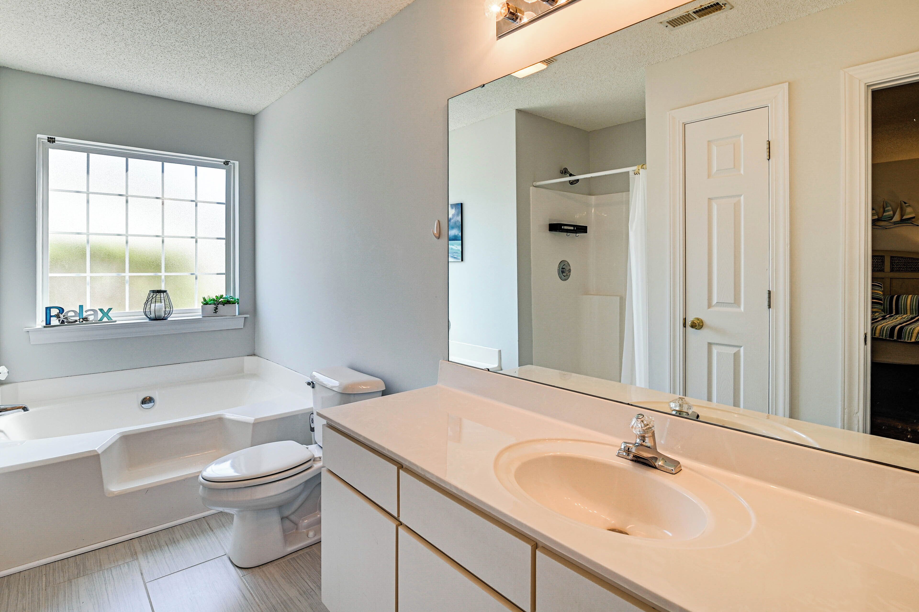 A modern bathroom with a bathtub, toilet, and sink.