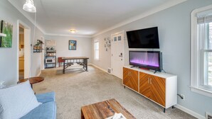 A living room with a sofa, coffee table, TV, and a dining area with a table and chairs. - Wfh-friendly Abode w/ Home Gym in Cleveland (Cleveland)