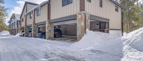 A multi-story residential building with a garage and parking area.