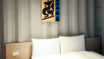 A hotel room with a bed, a wooden headboard, and a wall-mounted artwork.