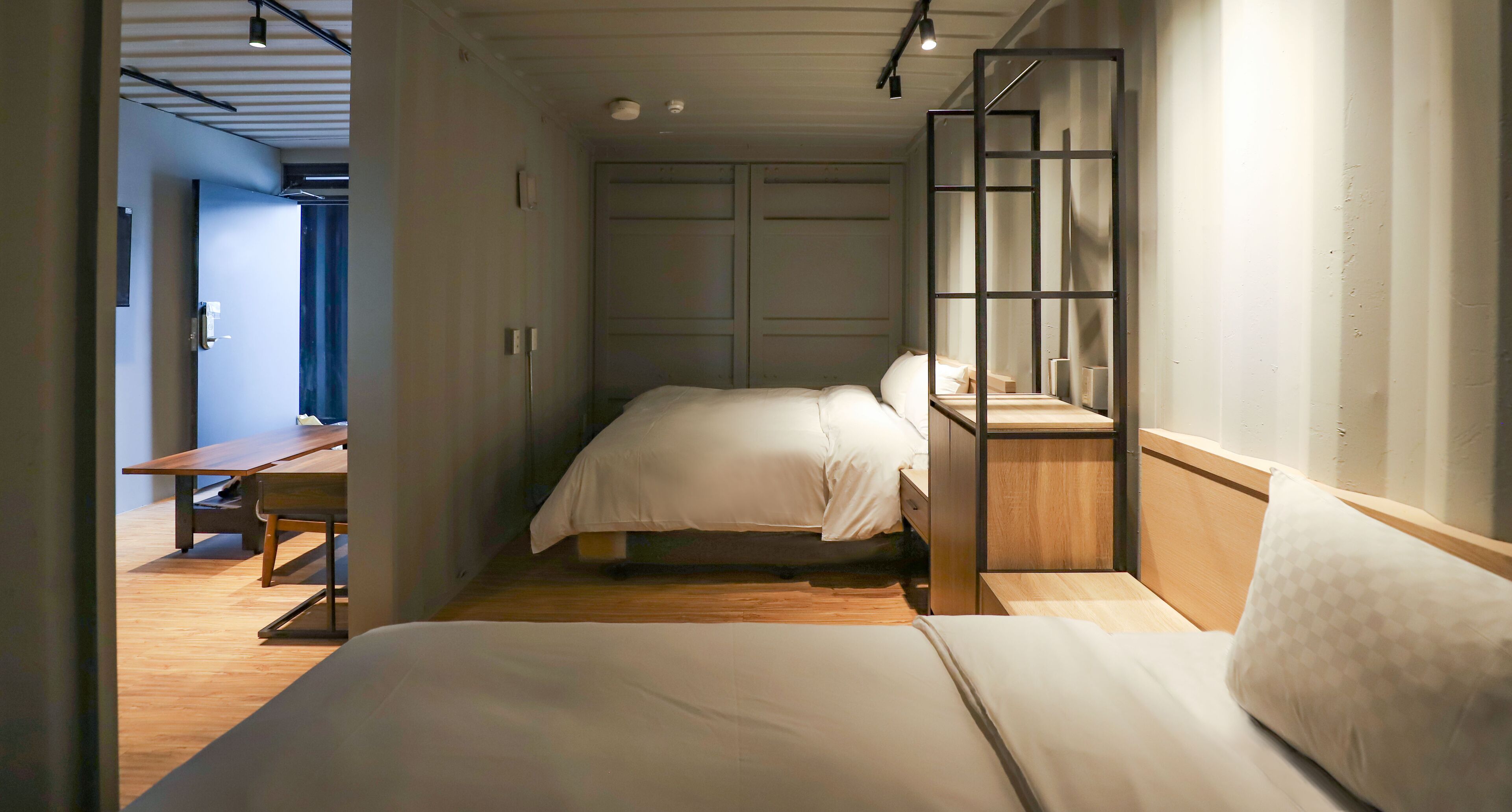 Een slaapkamer met een bed, bureau en een kledingkast.