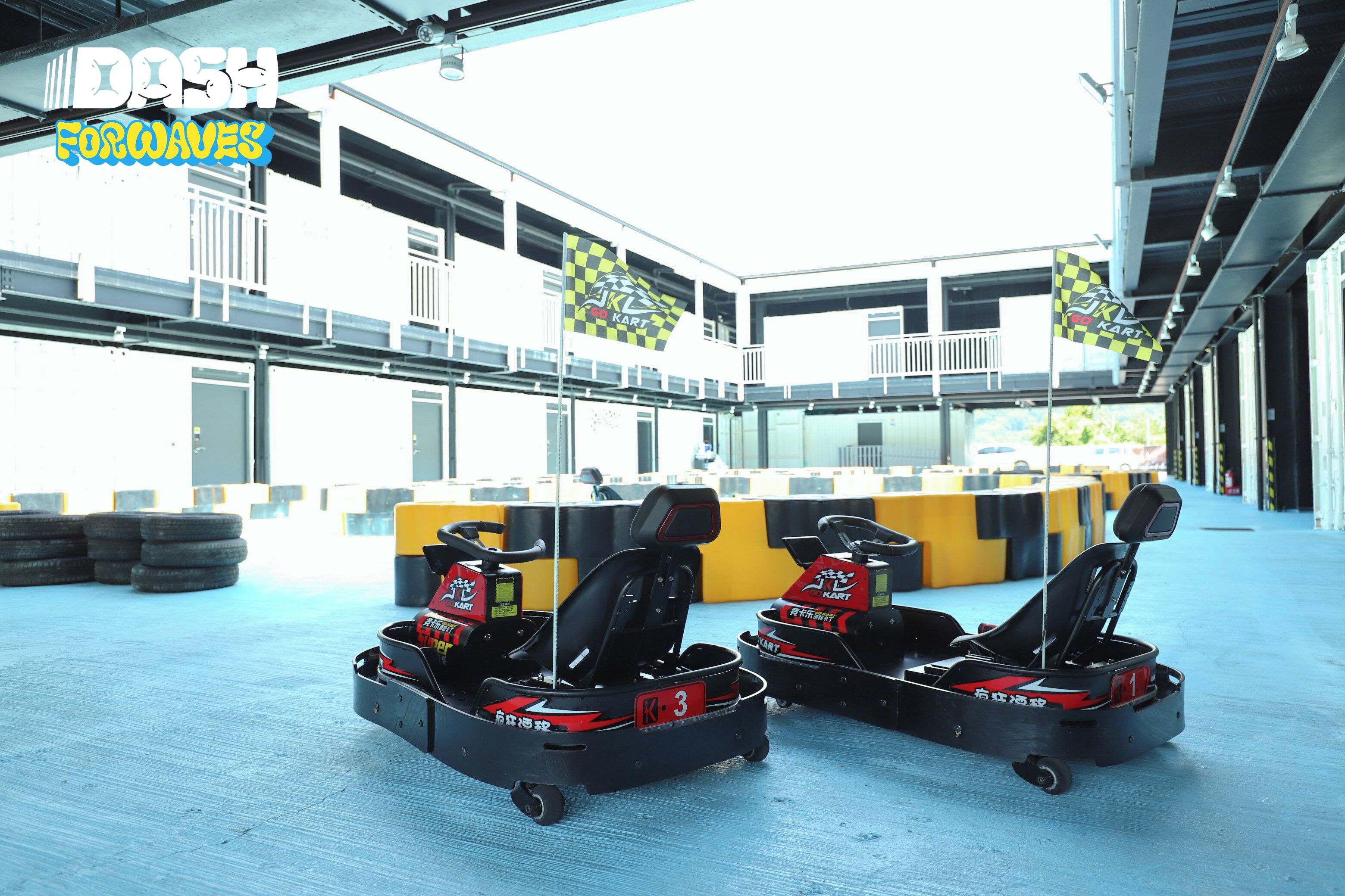 Una pista de karts con tres karts y una barrera amarilla.
