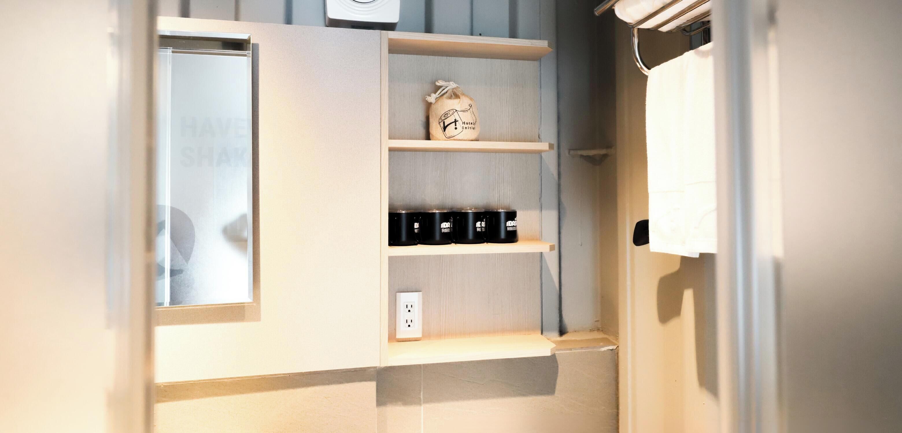 A kitchen with wooden shelves, a coffee machine, and a small bag labeled "Hotel Kitchen."