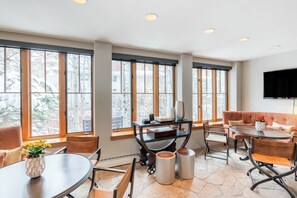 Enjoy a room with a large window offering a view of the outside, a dining table, sofa, and TV.