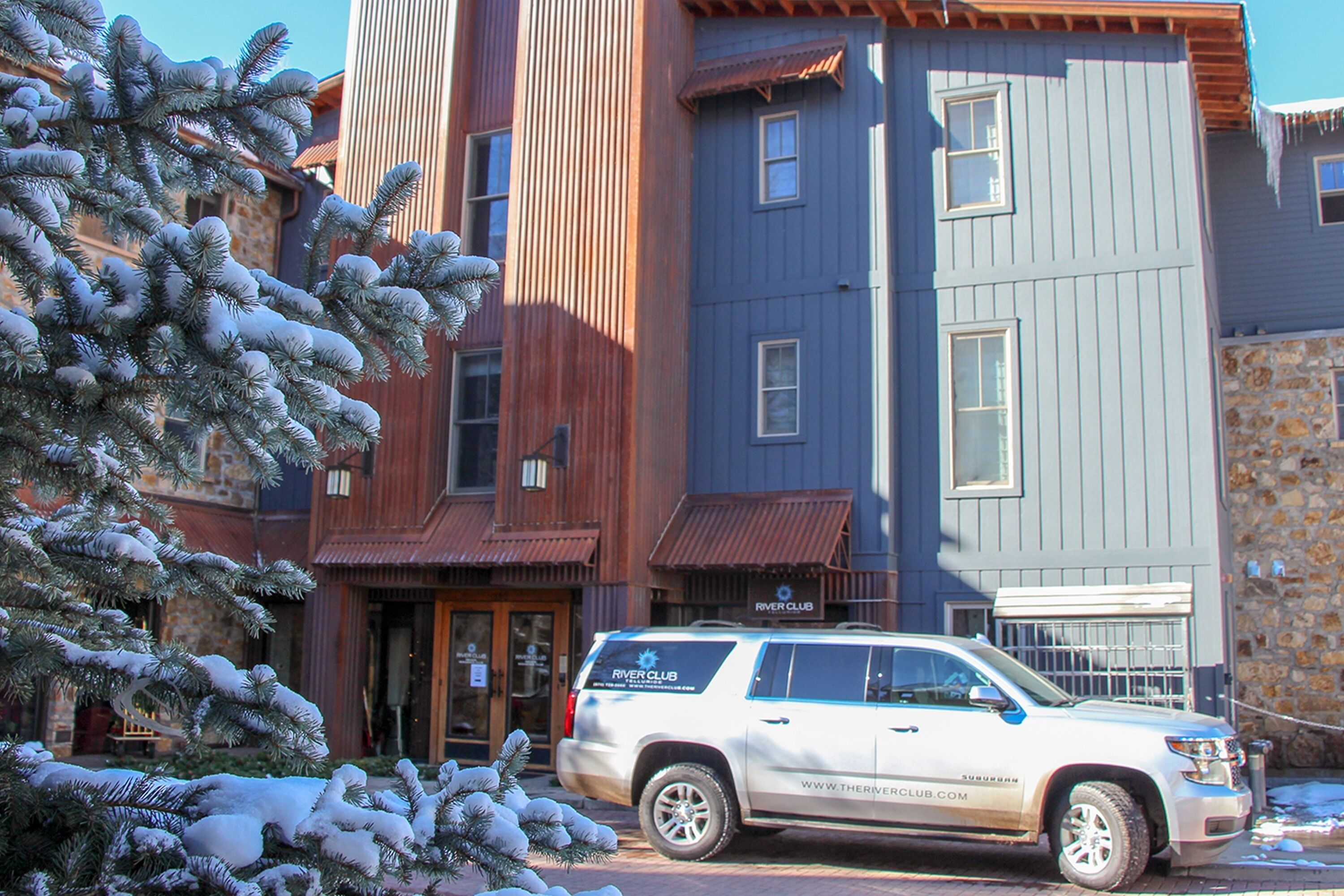 A multi-story building with a wooden facade and a blue upper section.