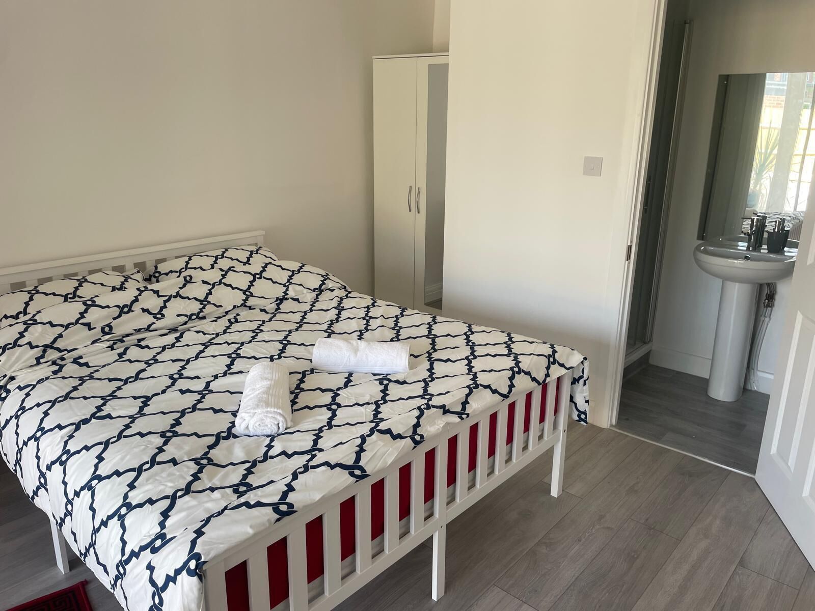Un dormitorio con cama, armario y baño con lavabo.