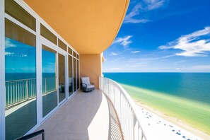 A balcony with a view of the ocean and beach.