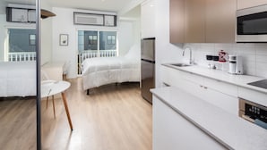 Een moderne keuken met witte kasten, roestvrijstalen apparatuur en een ontbijtbalk.