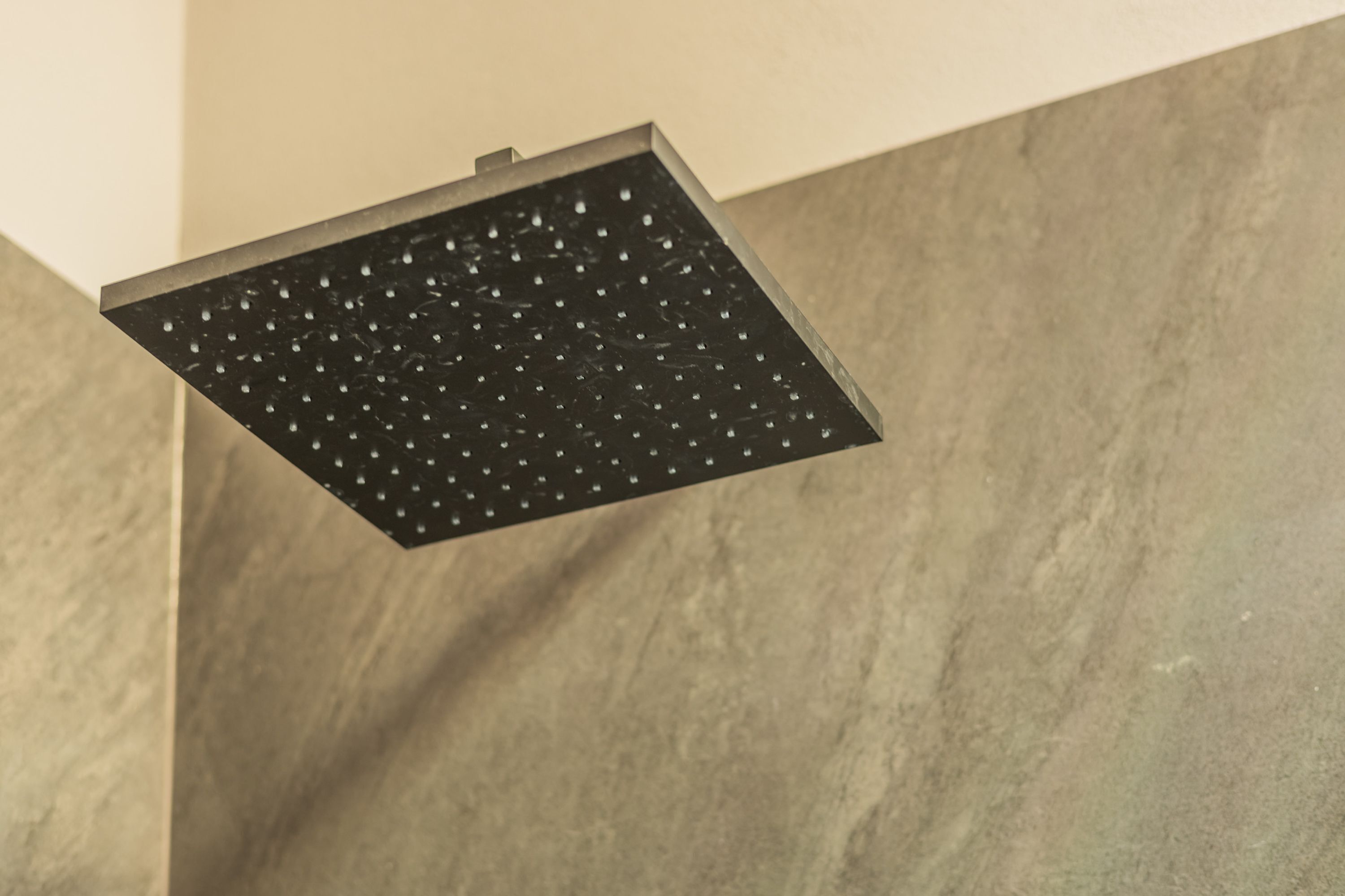 A showerhead with a square design and multiple water jets.
