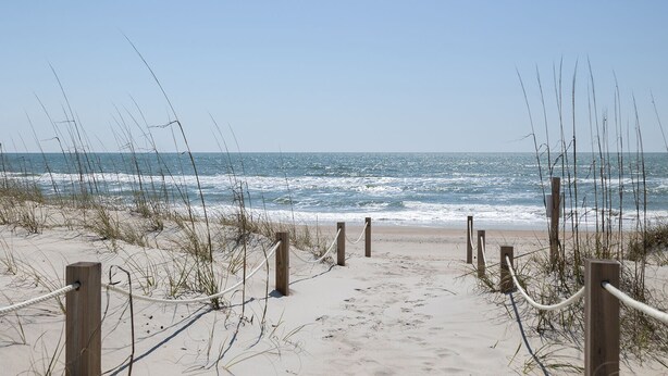 A sandy beach path leading to the ocean, with wooden posts and ropes marking the entrance. - Adjust Your Focus, Almost Oceanfront Duplex in Emerald Isle, NC! (Emerald Isle)