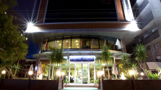 A hotel entrance with a glass facade, palm trees, and a sign reading "Hotel". - SEFA 2 BUTİK HOTEL (Corlu)