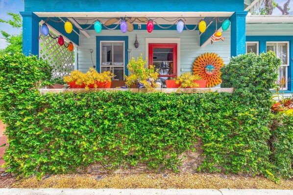 A house with a blue exterior, a red door, and a large sun decoration on the porch. - Casa De Sol in Historic District St. Augustine. Dog Friendly (St. Augustine)