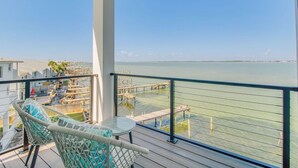 Un balcó amb vistes al mar, una zona de menjador i una cadira de relax.