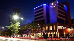 Et hotel med moderne design, flere etager og oplyst skiltning.