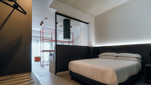 Une chambre à coucher moderne avec un grand lit, un bureau et une chaise.