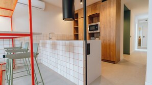 Une cuisine moderne dotée d’un îlot central, d’un four à micro-ondes et de meubles de rangement en bois.