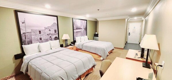 A hotel room with two beds, a desk, and a chair. There are two lamps on the desk and a large window with a view of a building. - Super 8 by Wyndham Temple I-35 (Temple)