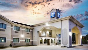 Hotel amb disseny modern, que destaca per un gran vestíbul amb finestres apuntades i zona coberta. Hi ha indicadors de 'SureStay' i 'Sofitel' que identifiquen les marques de l'hotel.