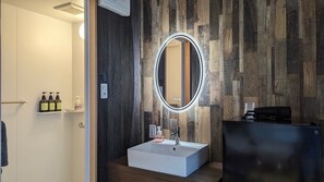 Sink, mirror, and cabinet in a bathroom with a textured panel design.