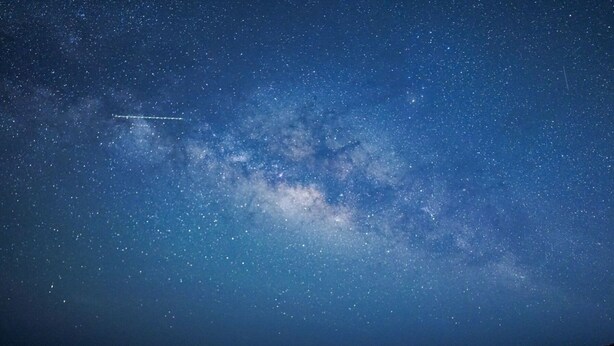 Two people sitting on a beach under a starry night sky. - Yonaguni-mumbu Airport Hotel (Yonaguni)
