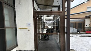 A narrow corridor with a glass door leading to a room. - Minpaku Ota Building 3 (Otaru)