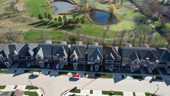 A residential area with a row of houses, a golf course, and a pond. - Serene High-celling Retreat in Upsacle and Safe Neighbourhood (Oakville)