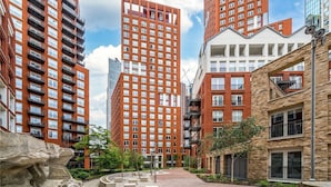 A modern urban residential area with high-rise buildings, a central plaza, and a mix of brick and glass facades. - Luxury 2 Bedroom Apartment Near Central London (London)