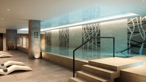 A modern indoor pool area with glass walls, a staircase, and abstract art on the walls. - Luxury 2 Bedroom Apartment Near Central London (London)