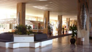 A spacious lobby with a modern design, featuring a seating area with sofas and potted plants, and a high ceiling with a grid pattern. - Marazul DEL SUR Face A LA MER (ADEJE)