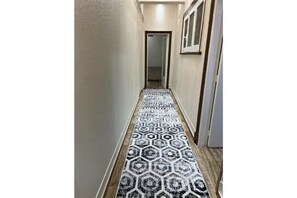 Stylish hallway with a geometric patterned carpet and a door leading to further accommodations.