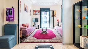 A living room with a purple telephone, two sofas, a red carpet, and a glass cabinet with decorative items. - Hôtel Mauritania Centre Tangier (Tangier)