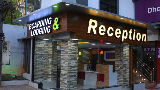 Un área de recepción con fachada de madera y ventanas de vidrio, identificada con el letrero "Boarding & Reception".
