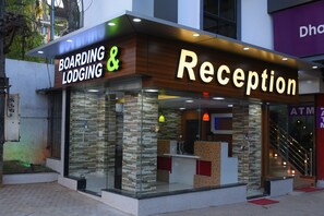 Un área de recepción con fachada de madera y ventanas de vidrio, identificada con el letrero "Boarding & Reception".